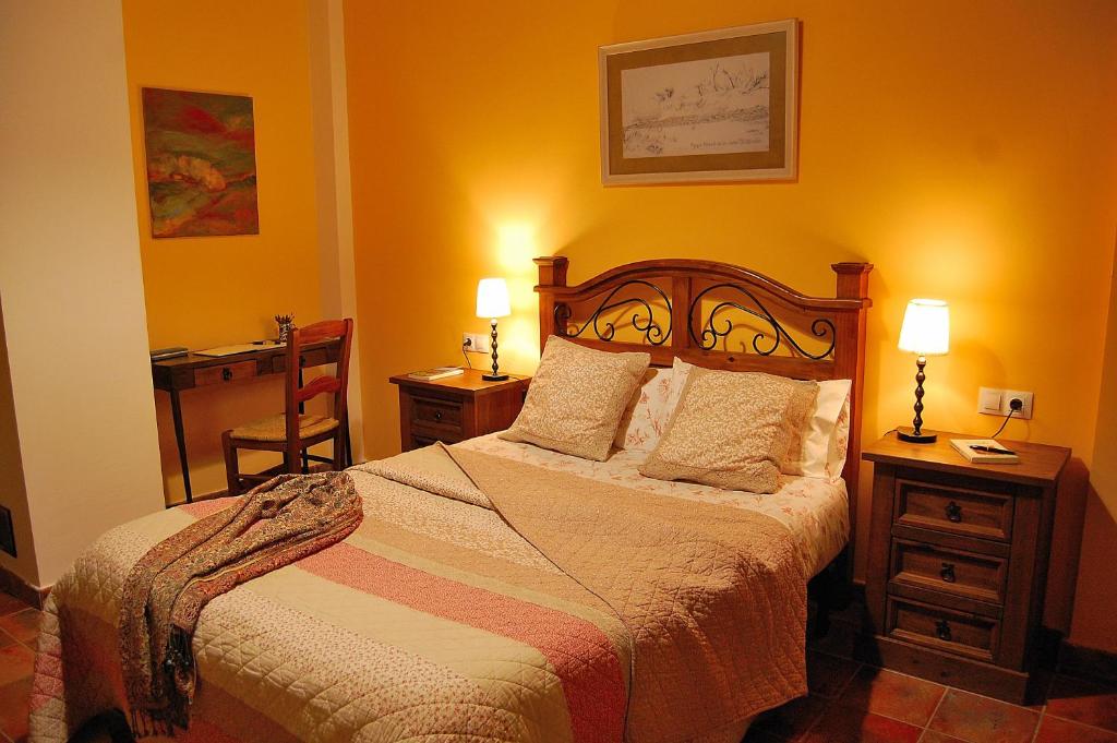 um quarto com uma cama e duas mesas e dois candeeiros em Casa Rural Estarrún em Aísa