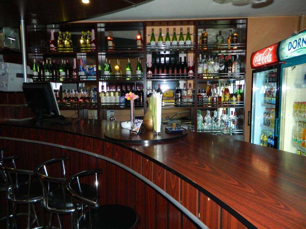 a bar with a wooden counter and bar stools at Vila Tom Cris in Campina