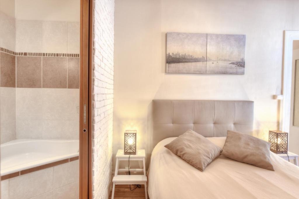 1 dormitorio con cama y bañera en L'Appart Elegance Part Dieu, en Lyon