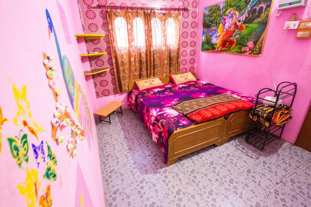 um quarto com uma cama num quarto cor-de-rosa em Somit Paying Guest House em Varanasi