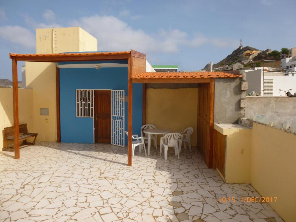 a patio with a blue door and a table and chairs at Penthouse Télétravail in Mindelo