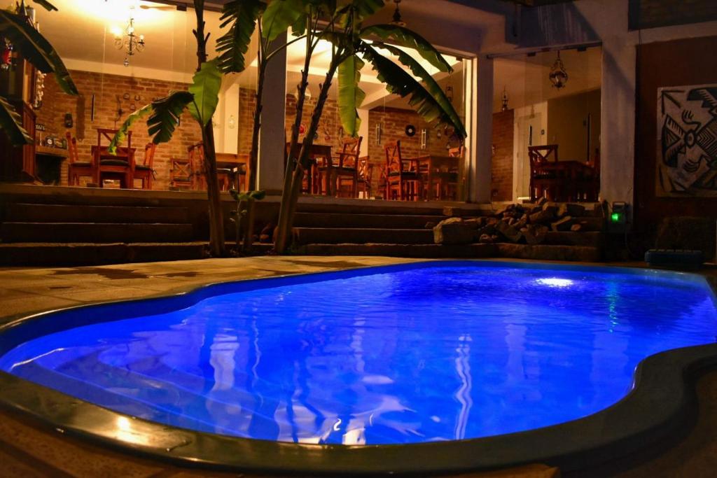 a blue swimming pool in a room with a bar at El Viejo Molino in Chilecito