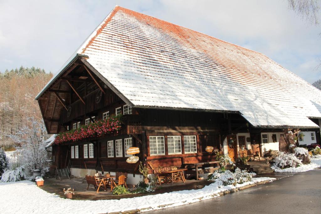 a large wooden house with snow on the roof at Rommelehof in Gutach