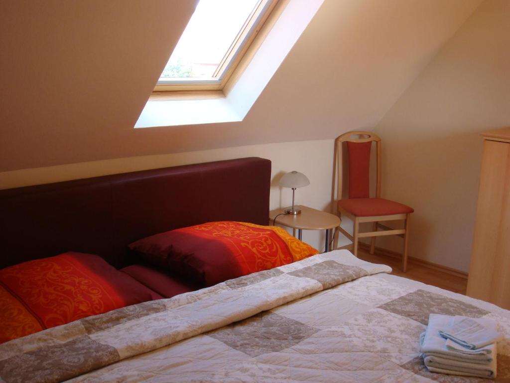a bedroom with a bed and a window and a chair at Pension Roez in Göhren-Lebbin