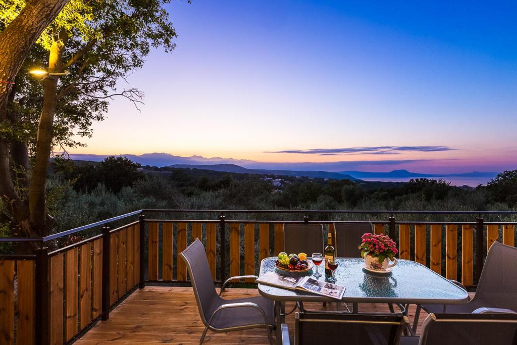 a table on a deck with a view of the mountains at Villa Ifigenia in Prinés