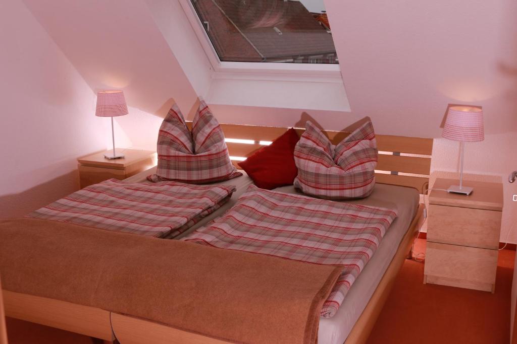 ein Schlafzimmer mit einem Bett mit zwei Kissen darauf in der Unterkunft Strandblick in Horumersiel