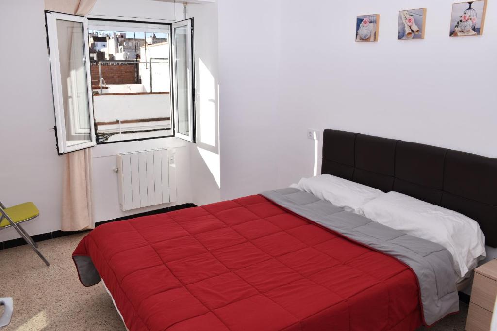 a bedroom with a red bed and a window at Rosesapparts Onamar & Parking in Roses