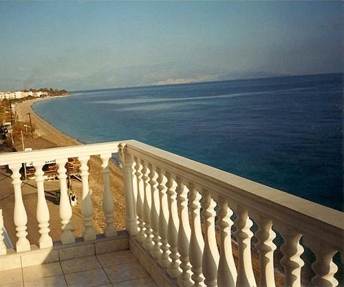 a view of the ocean from the balcony of a building at Antonios Rooms in Akrata