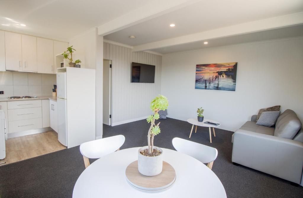a kitchen and a living room with a table and chairs at CBD Apartments Launceston in Launceston