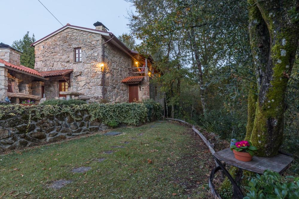 una casa de piedra con un banco delante en Varanda do Mouro, en Podame