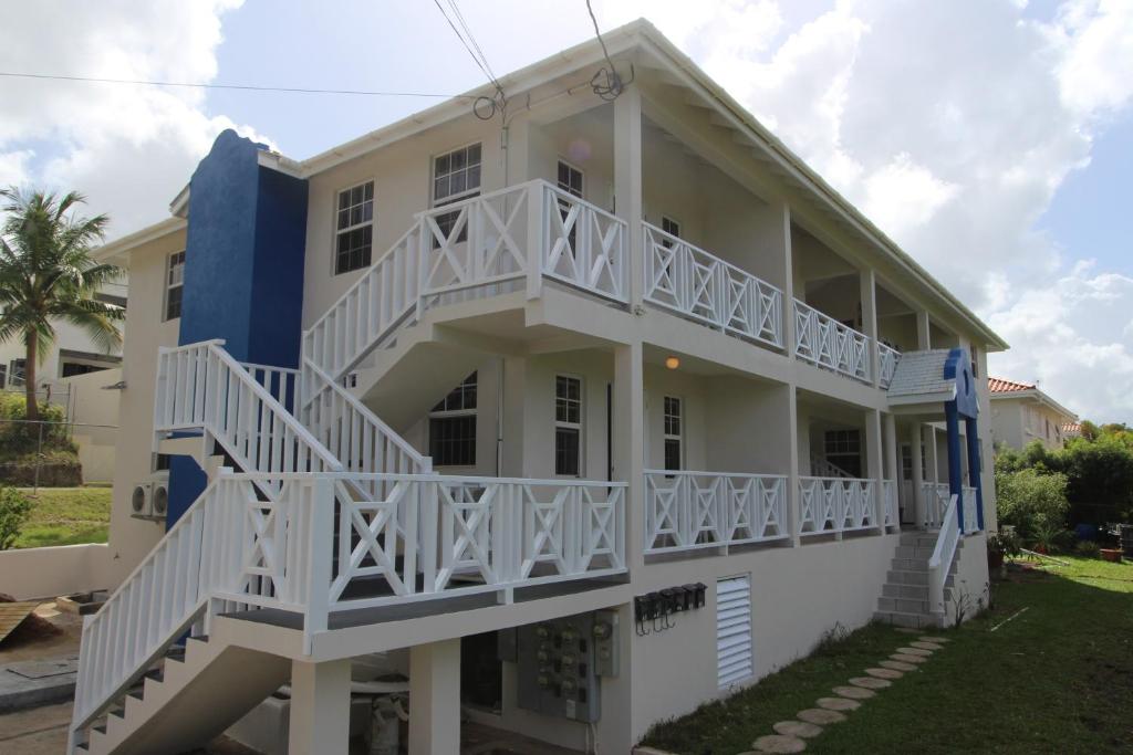ein großes weißes Haus mit weißen Geländern in der Unterkunft Turtle Ridge Apartments in Saint James