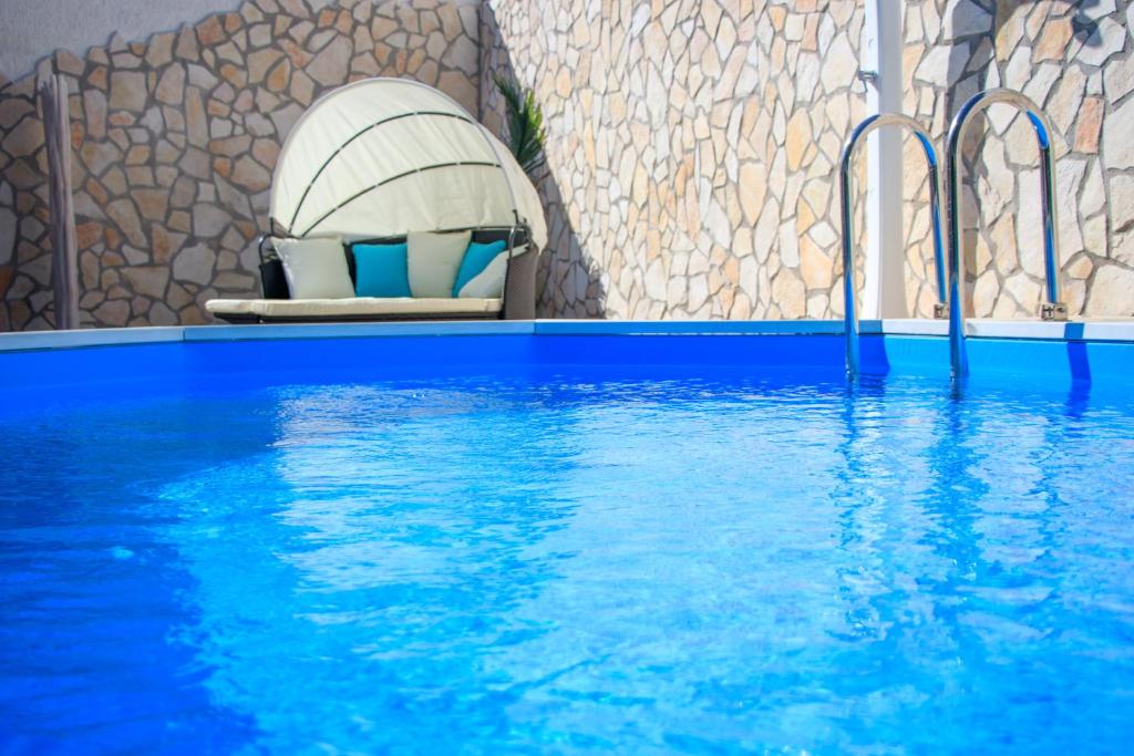 una piscina di acqua blu con una sedia e una parete di roccia di Il Giardino delle Jacaranda a Talsano