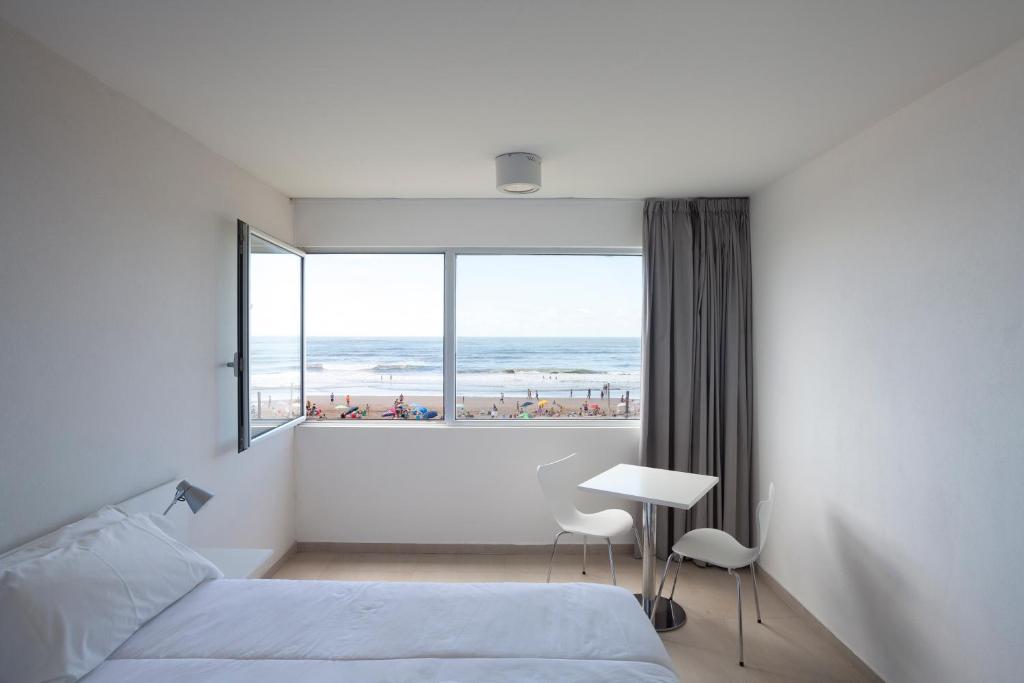 1 dormitorio con cama y vistas a la playa en Vista Hotel en Villa Gesell