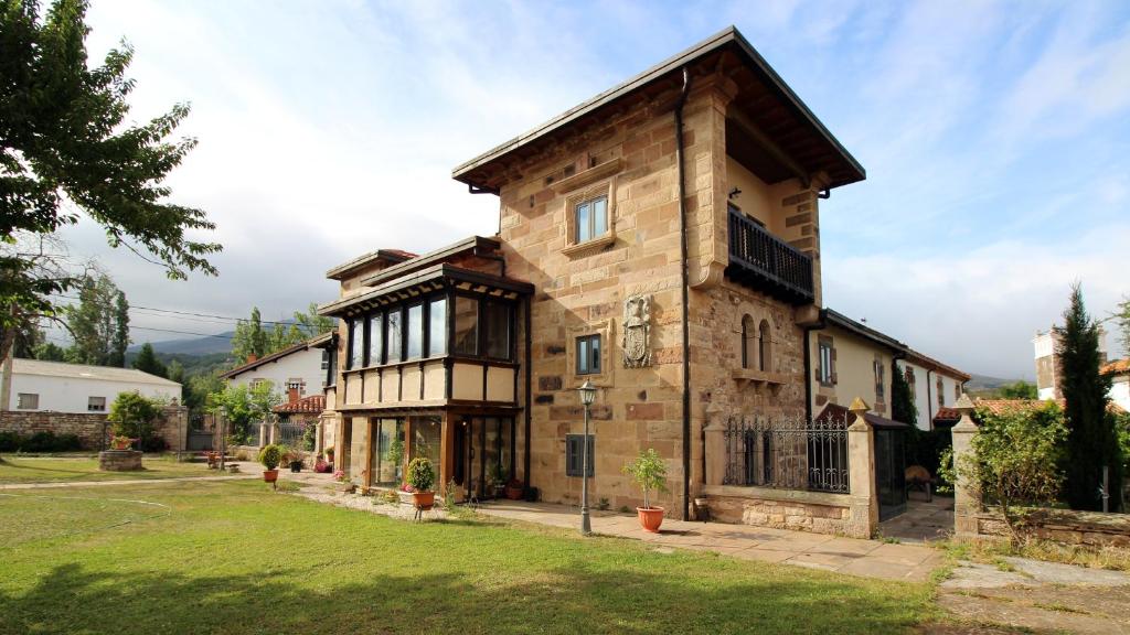 uma grande casa de pedra com um telhado de gambrel em Las Casonas de Don Pedro em Reinosa