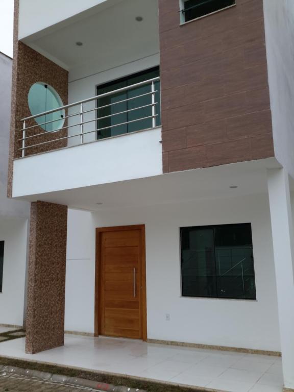una vista di una casa con una porta di legno di Ótima Localização - 4 Quartos a Porto Seguro