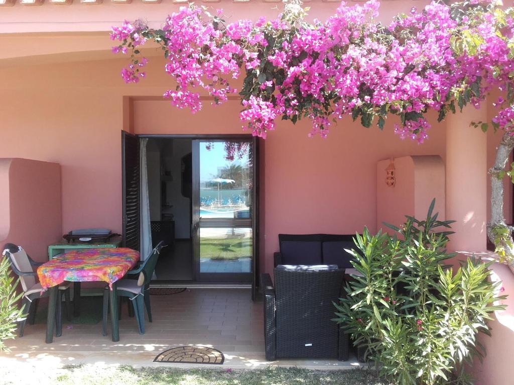 a patio with a table and purple flowers at Albufeira INN - Casa Litty - Bellavista T1 duplex in Albufeira