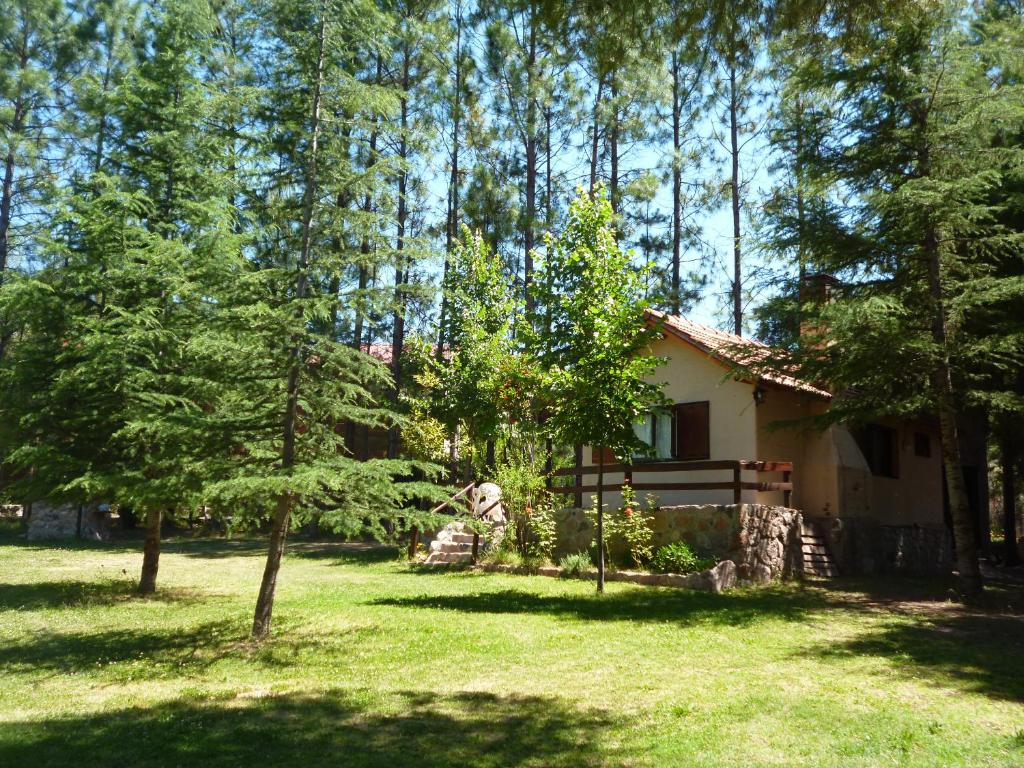 ein Haus inmitten eines Gartens mit Bäumen in der Unterkunft El Pinar Suizo in Cacheuta
