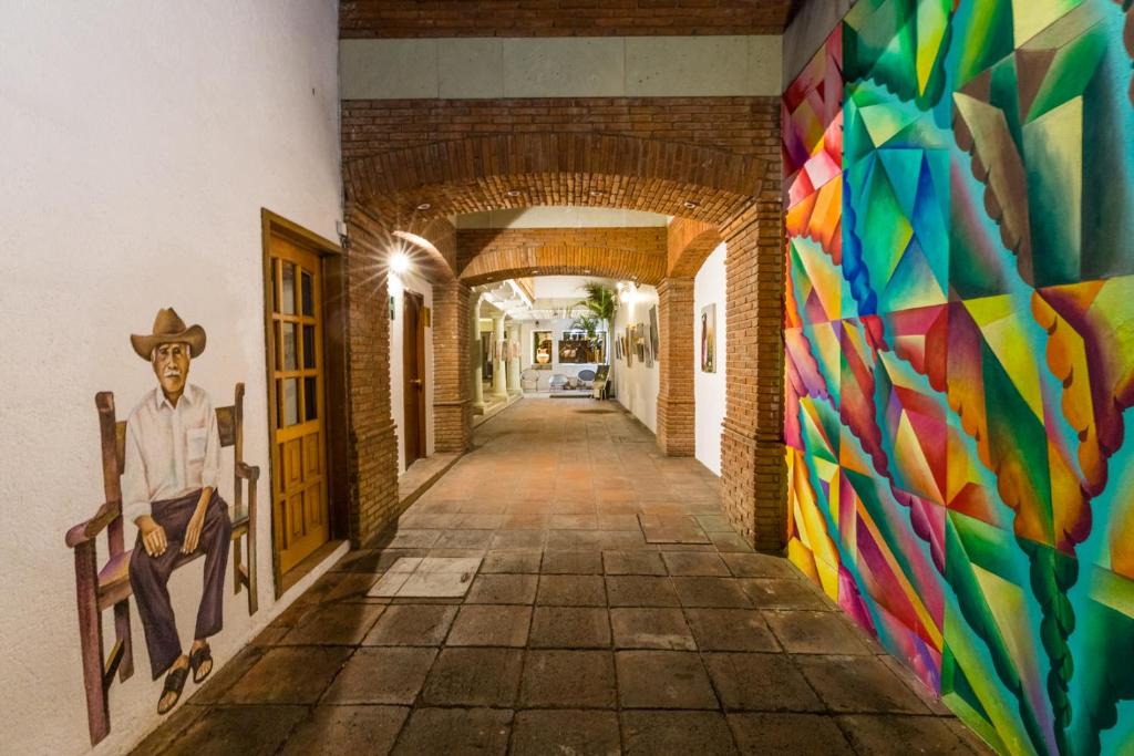 Une allée avec une fresque murale dans l'établissement NaNa Vida Hotel Oaxaca, à Oaxaca