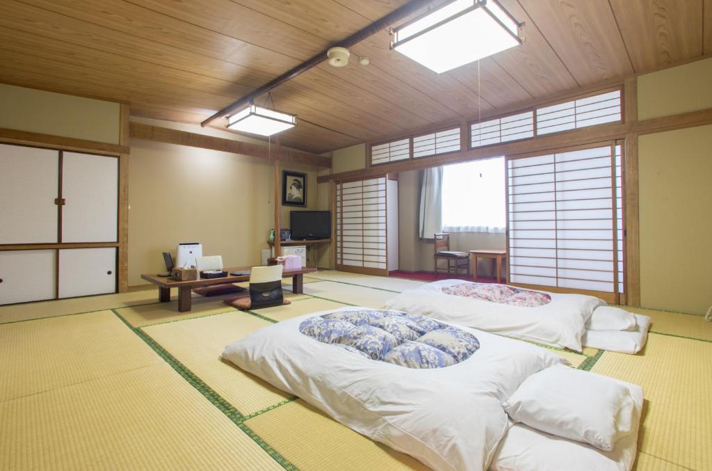 a large room with two beds in it at Masunoi in Mie