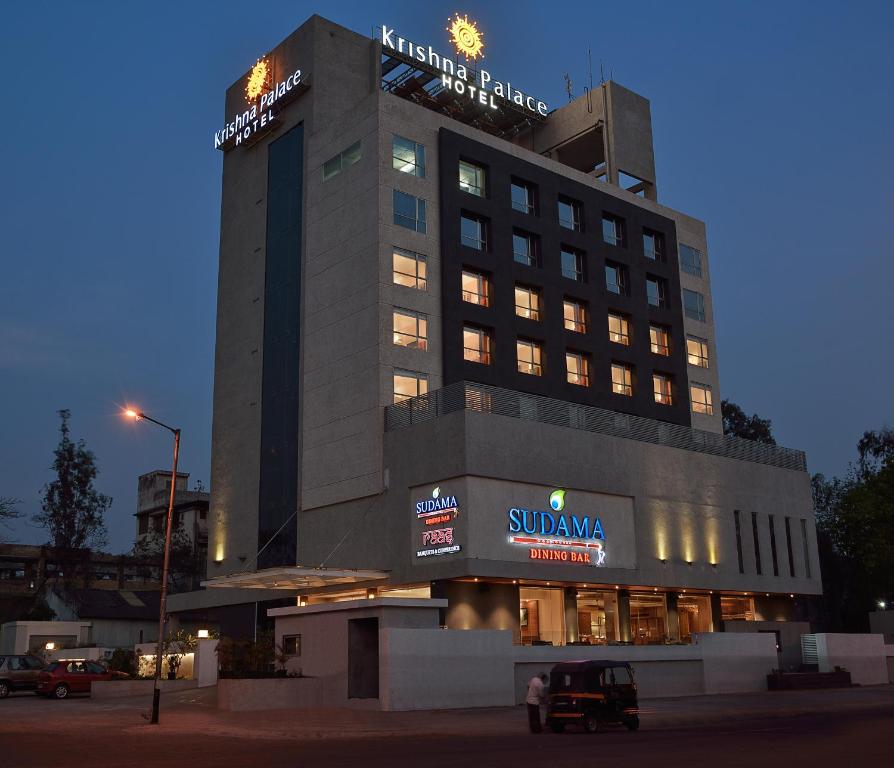 un bâtiment d'hôtel avec un panneau en haut dans l'établissement Krishna Palace Hotel - Ambernath, à Amarnāth
