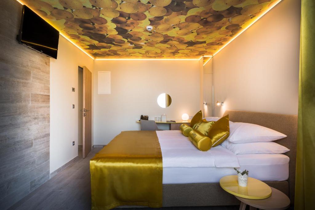 a bedroom with a bed with a yellow ceiling at Hotel Vinotel Gospoja in Vrbnik