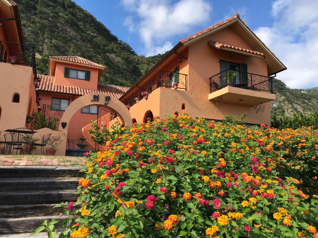 een huis met bloemen ervoor bij Wishingwell B&B in Donghe