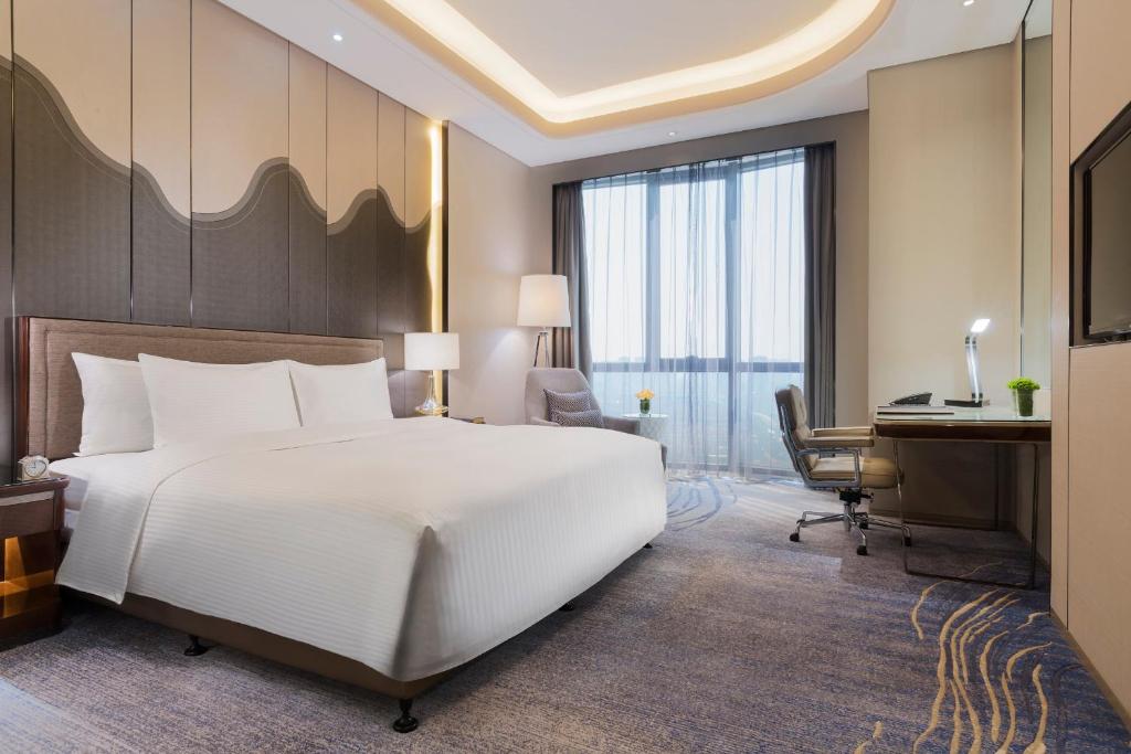 A bed or beds in a room at Wanda Realm Changzhou