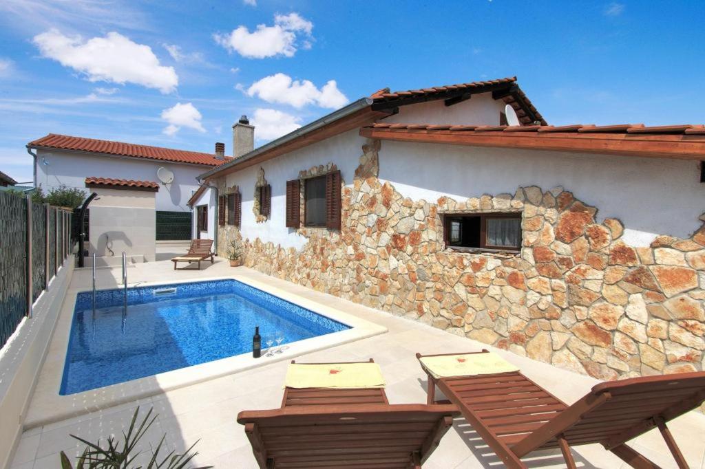 eine Villa mit einem Pool vor einem Haus in der Unterkunft House Fazana 975 in Fažana