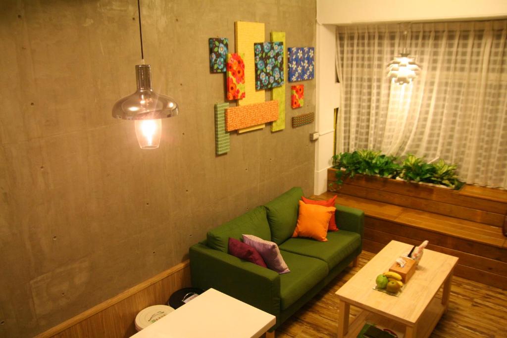 a living room with a green couch and a table at You Ai Heya Homestay in Tainan