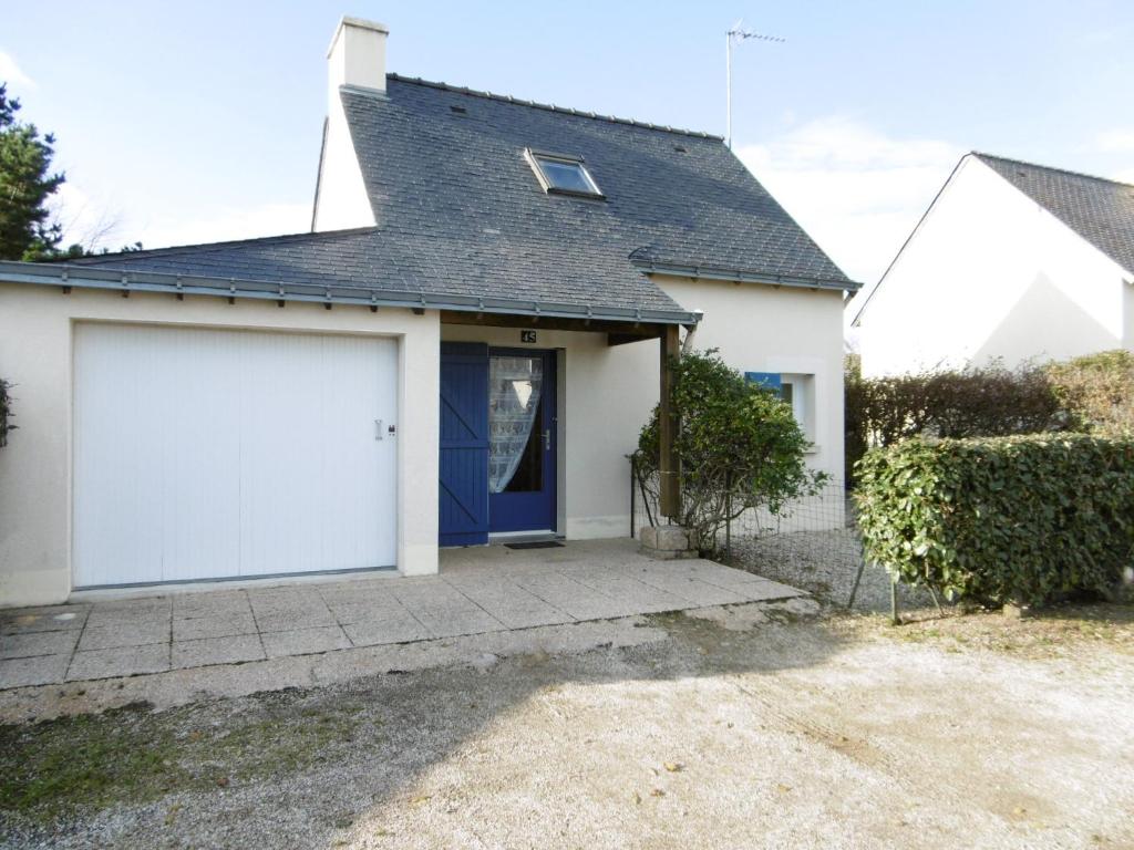 een wit huis met een garage bij Maisonnette Maria in Saint-Gildas-de-Rhuys