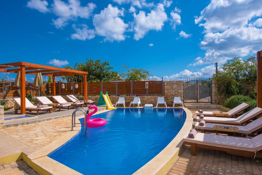 a pool with chaise lounge chairs and a swimming pool at Sunshine Villa with Private Pool by Estia in Hersonissos