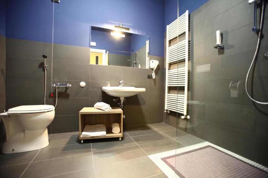 a bathroom with a toilet and a sink and a mirror at Valtidone Hotel in Borgonovo Val Tidone