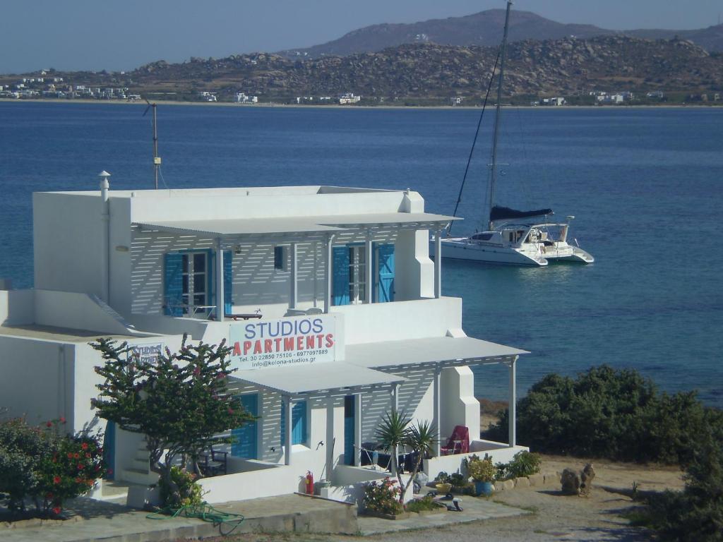 un edificio blanco junto al agua con un barco en Kolona Studios en Mikri Vigla