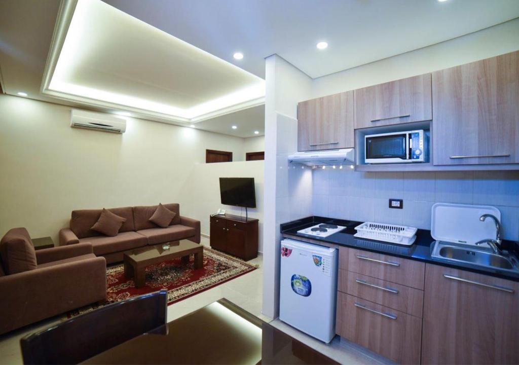 eine Küche und ein Wohnzimmer mit einem Sofa und einem Herd in der Unterkunft Al Jawhara Suites in Beirut