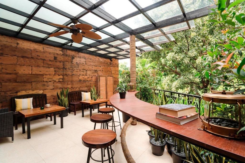 un patio con tavoli, sedie e soffitto in vetro di Treehouse Suites - Boutique Serviced Apartment a Giacarta