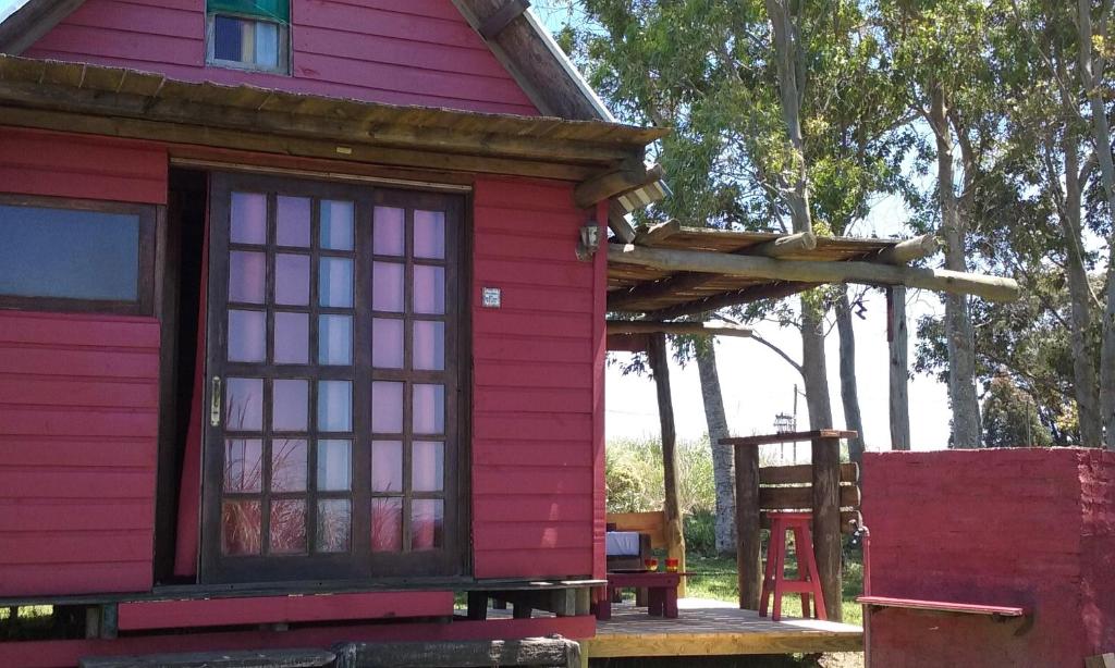 una casa roja con una ventana y una escalera en Tacamita, en La Pedrera