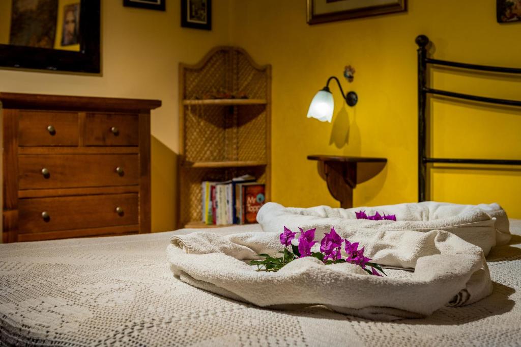 łóżko z kocem i fioletowymi kwiatami w obiekcie Villa Eden con piscina a Scopello w mieście Castellammare del Golfo