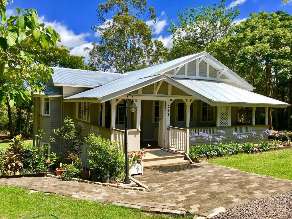 una piccola casa verde con portico di Keillor Lodge a Maleny