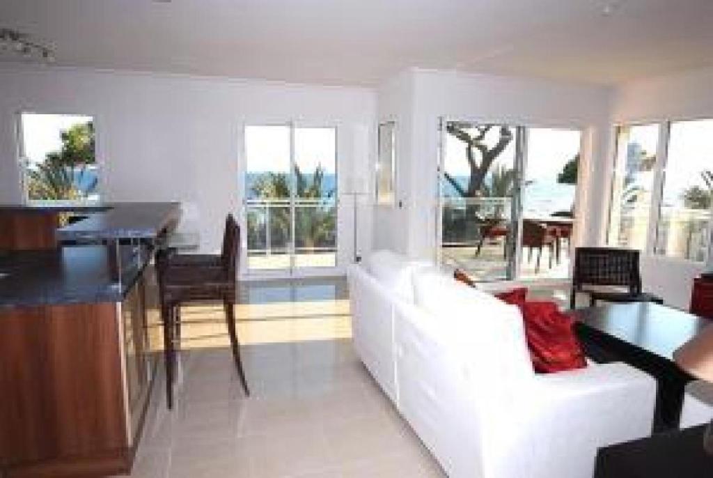 een woonkamer met een witte bank en een tafel bij Stunning 2 Bed Apt on the seafront of Cannes in a high class secure building with swimming pool 463 in Cannes