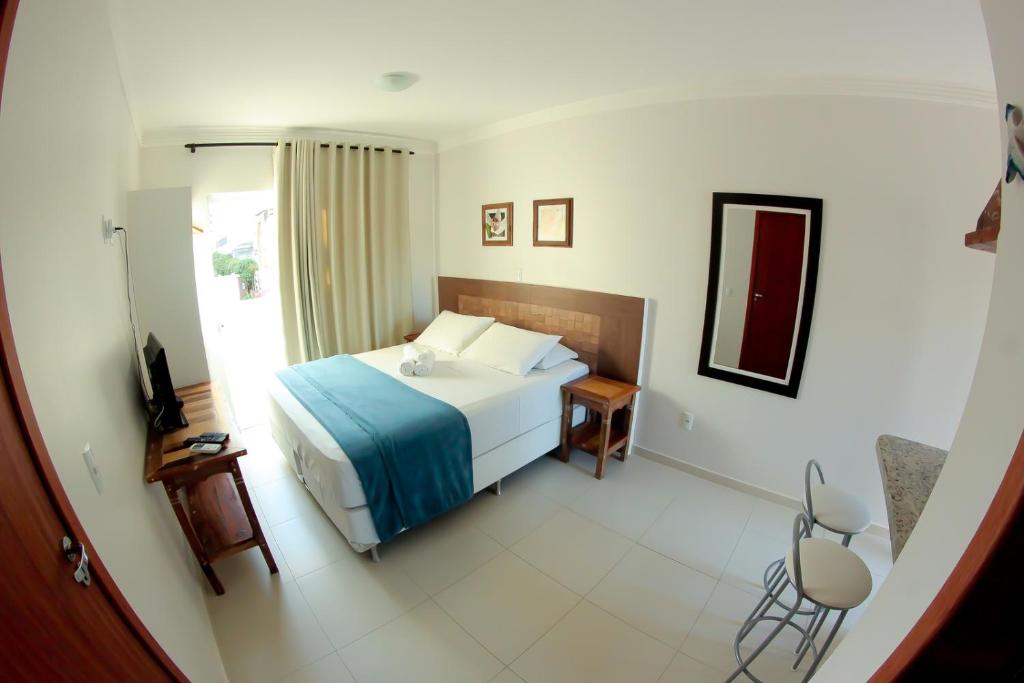 a hotel room with a bed and a window at Pousada Águas de Bombinhas in Bombinhas