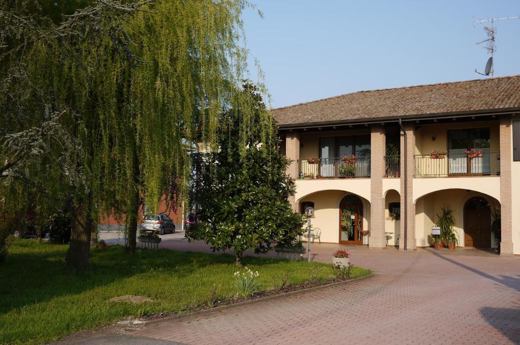 a building with a tree in front of it at Agriturismo Mongiorgi "I Salici" in Anzola dell'Emilia