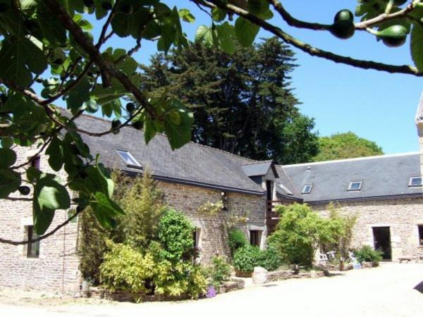 a large brick building with a roof at Les Pieds dans l'Herbe in Rosporden