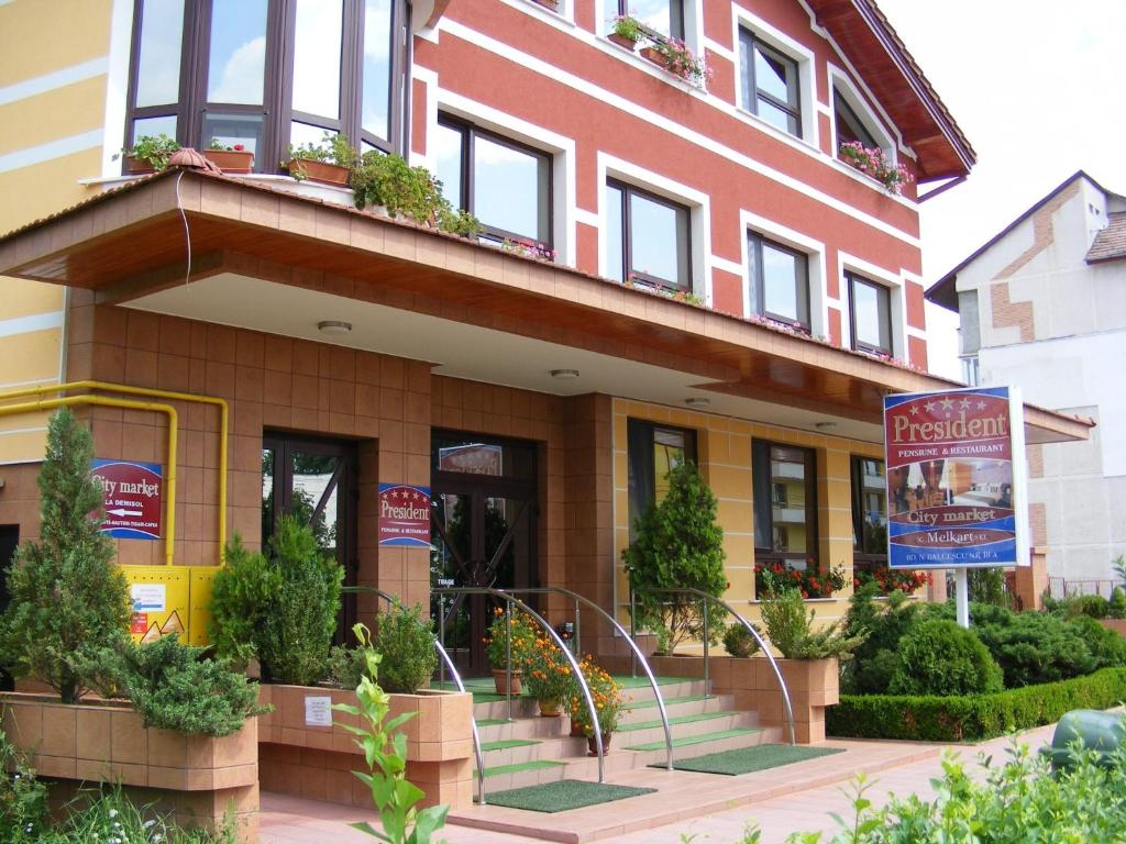 a building with stairs and plants in front of it at Pensiunea President in Deva