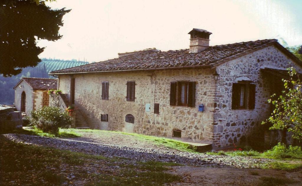 サン・ジミニャーノにあるAgriturismo Podere Cappellaの煙突付きの古い石造りの建物