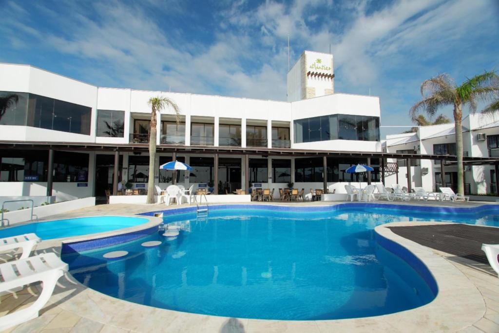 a large swimming pool in front of a building at Hotel Atlântico in Bombinhas