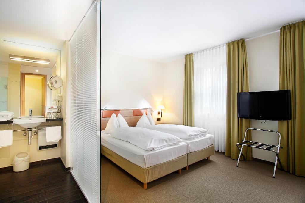 a hotel room with a bed and a sink at Hotel am Jakobsmarkt in Nuremberg