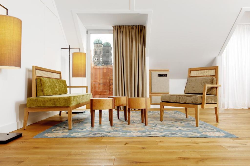 a living room with two chairs and a table at Louis Hotel in Munich