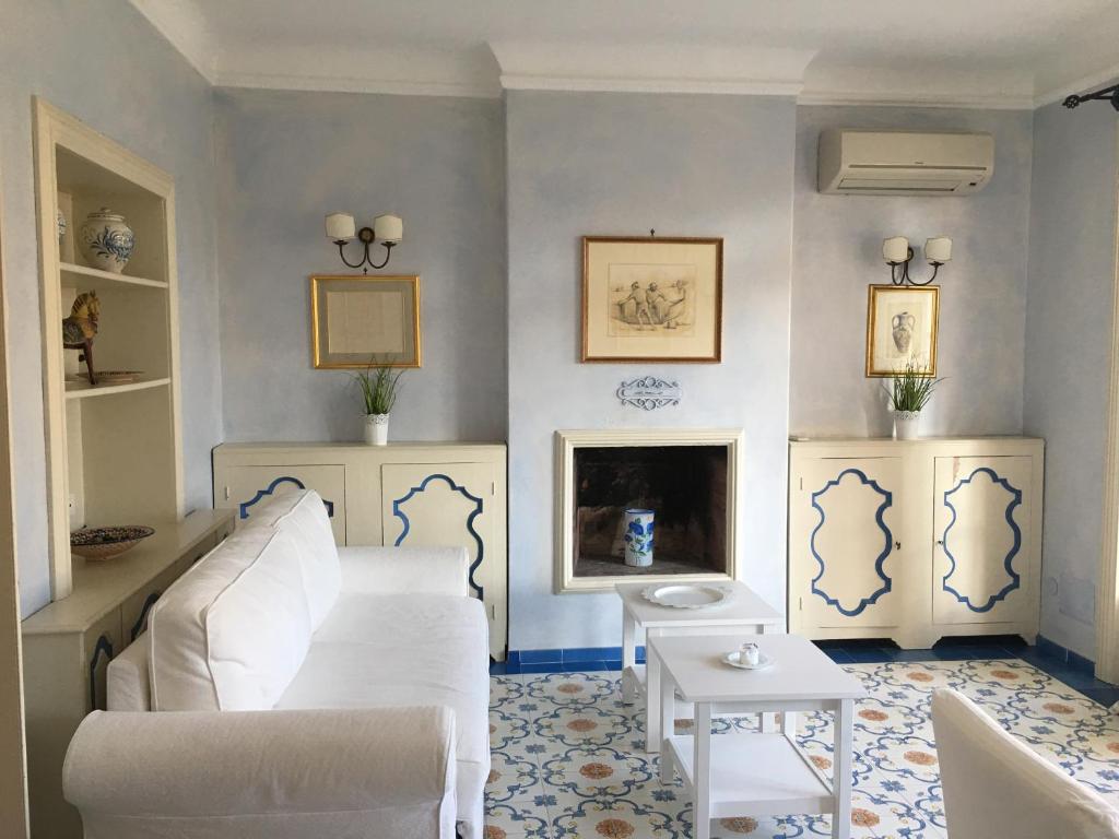 ein Wohnzimmer mit einem weißen Sofa und einem Tisch in der Unterkunft L'Atelier del Pittore Apartment in Taormina