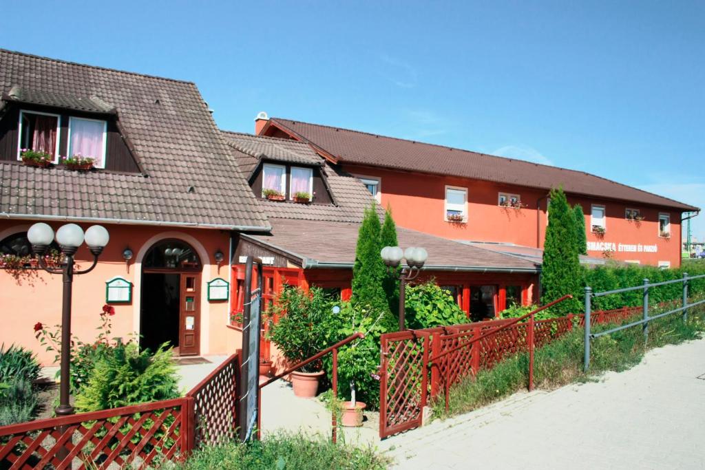 a house with a fence in front of it at Vasmacska Panzió in Komárom