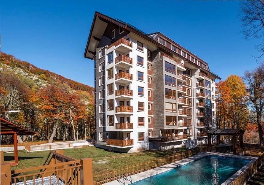 a large apartment building with a swimming pool in front of it at Departamento Sector Nevados de Chillan Wentrukal Turismo in Nevados de Chillan